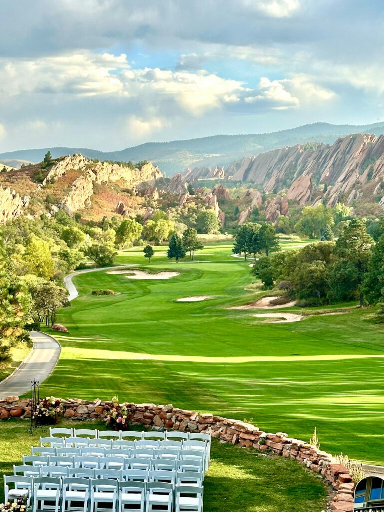 A scenic view of a golf course and mountains